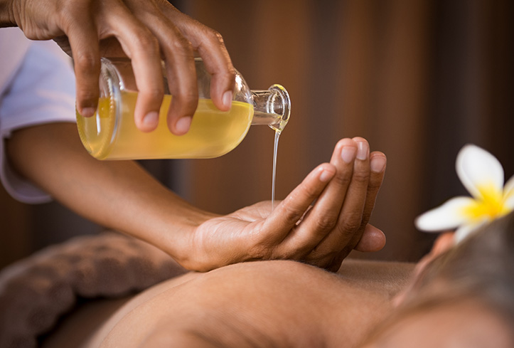 Therapist pouring massage oil at spa